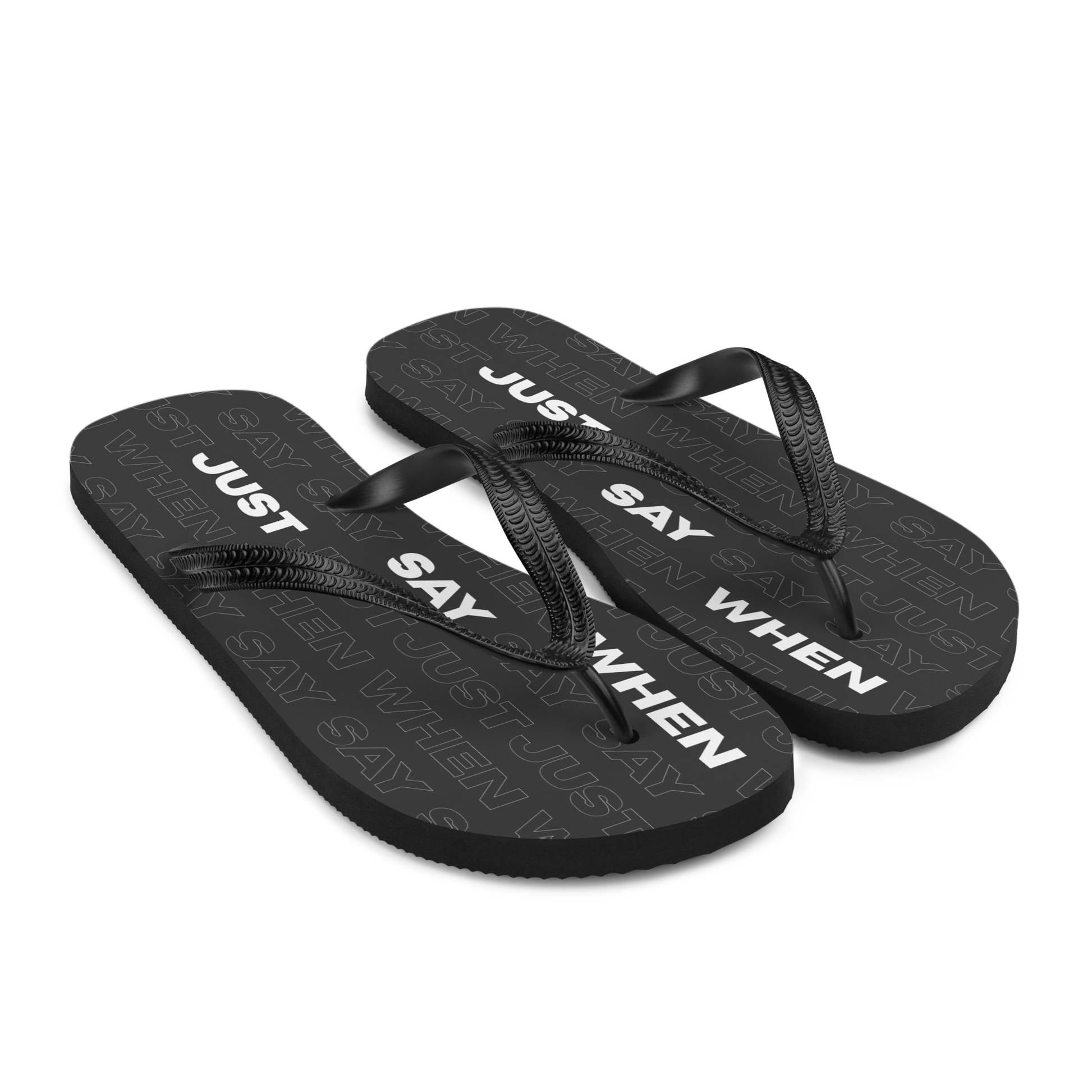 the capital flip-flops in black with bold white ‘just say when’ text and a subtle repeating pattern on the soles.
