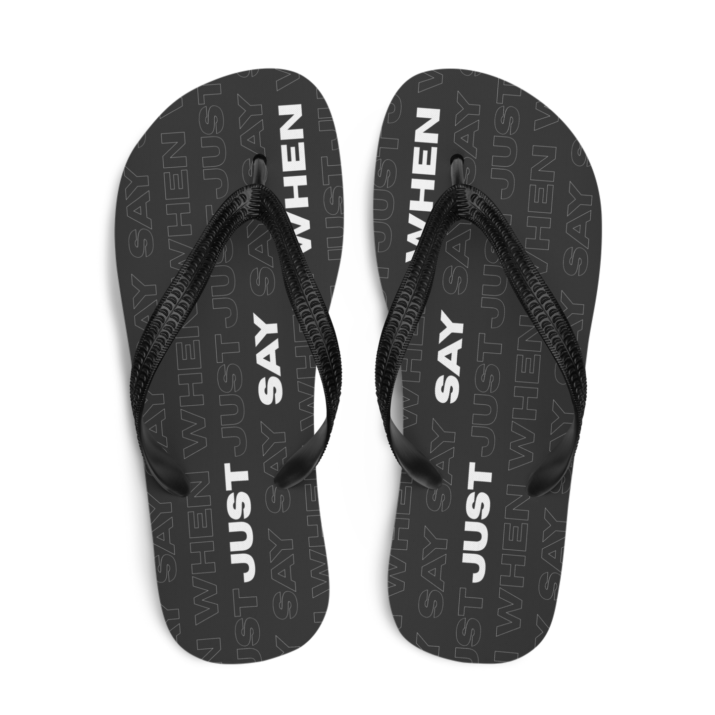top view of the capital flip-flops in black with bold white ‘just say when’ text and a subtle repeating pattern.