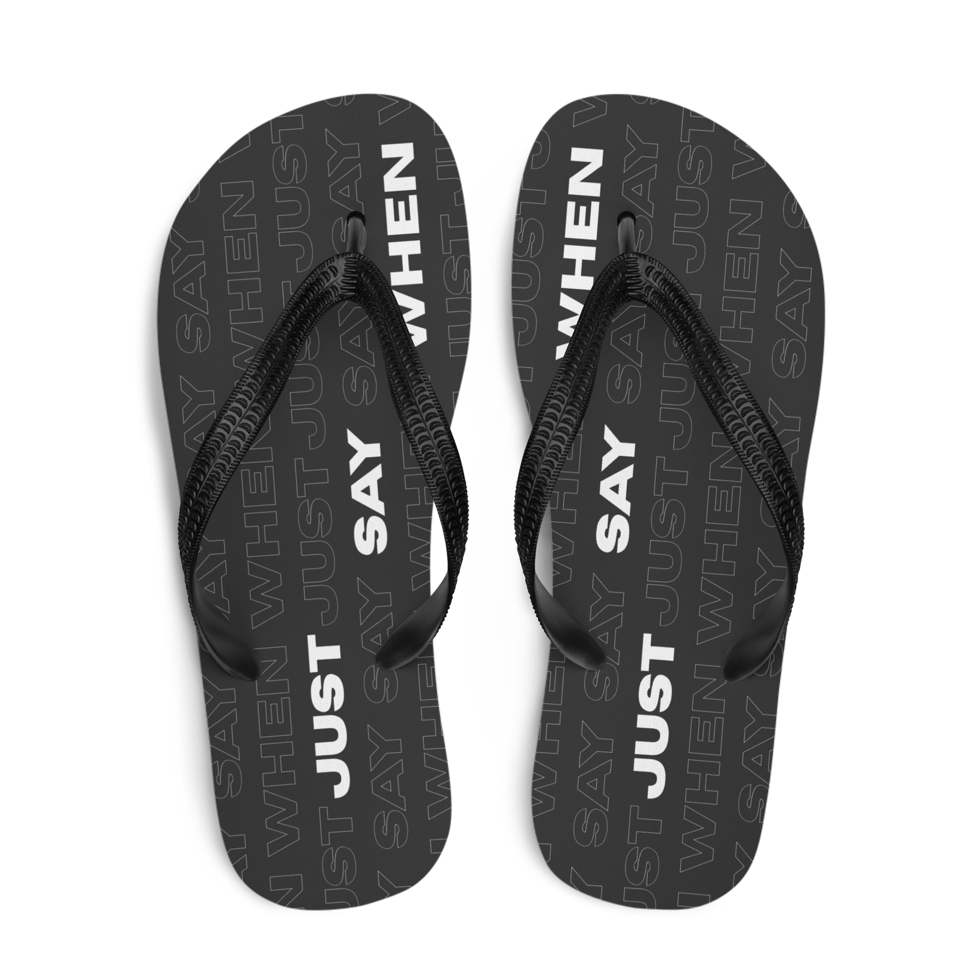 top view of the capital flip-flops in black with bold white ‘just say when’ text and a subtle repeating pattern.