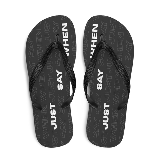 top view of the capital flip-flops in black with bold white ‘just say when’ text and a subtle repeating pattern.