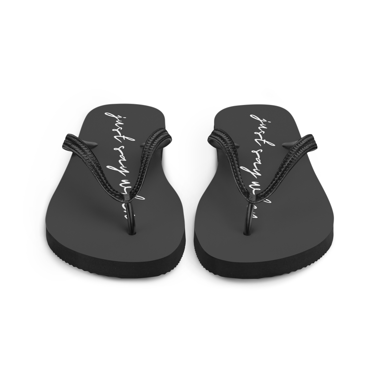 front view of the just say flip-flops in black featuring white cursive text that reads ‘just say when’.