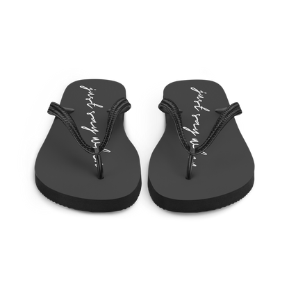 front view of the just say flip-flops in black featuring white cursive text that reads ‘just say when’.