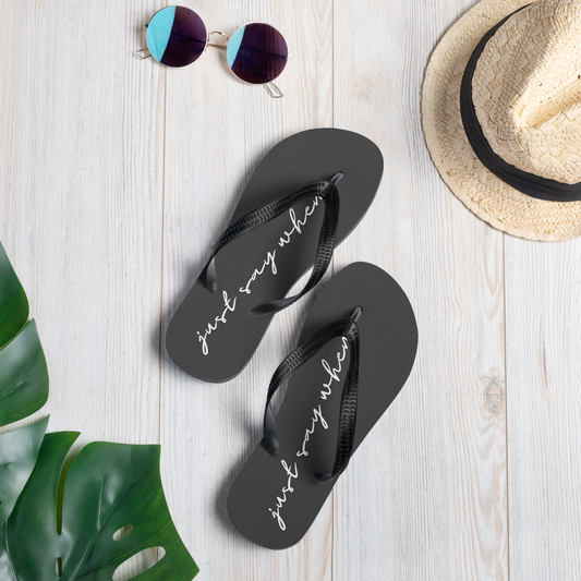 the just say flip-flops in black featuring white cursive text that reads ‘just say when’ with summer accessories.